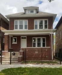 Outside of brick home with black metal fence