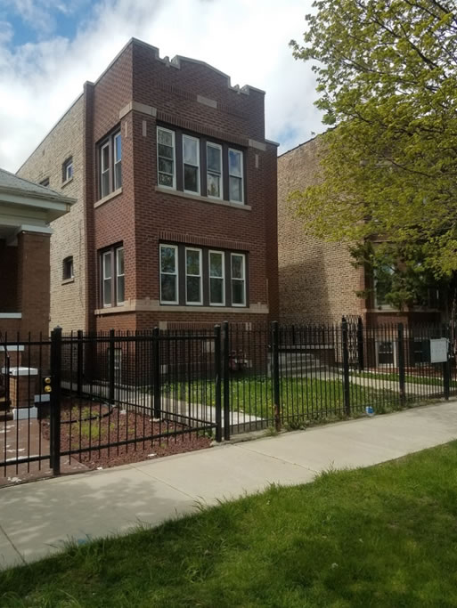 Outside of brick building with black metal fence