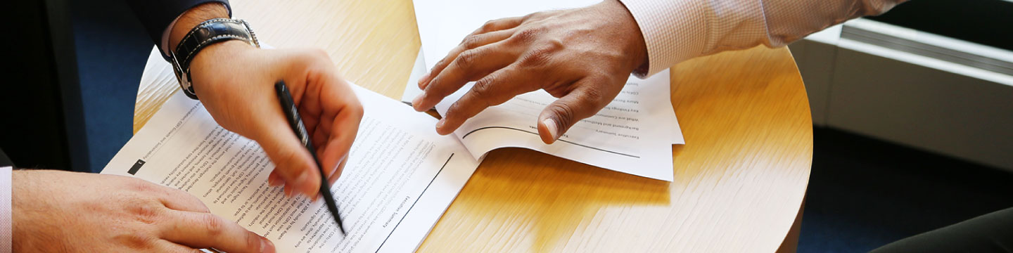The hands of two people completing a document