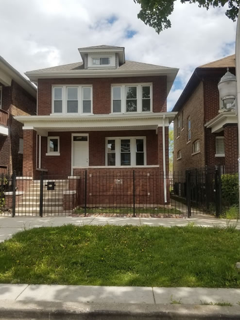 Outside of brick home with black metal fence