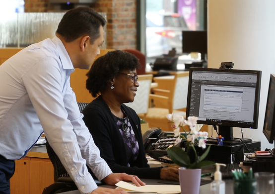 Man and woman at an office desk with computers